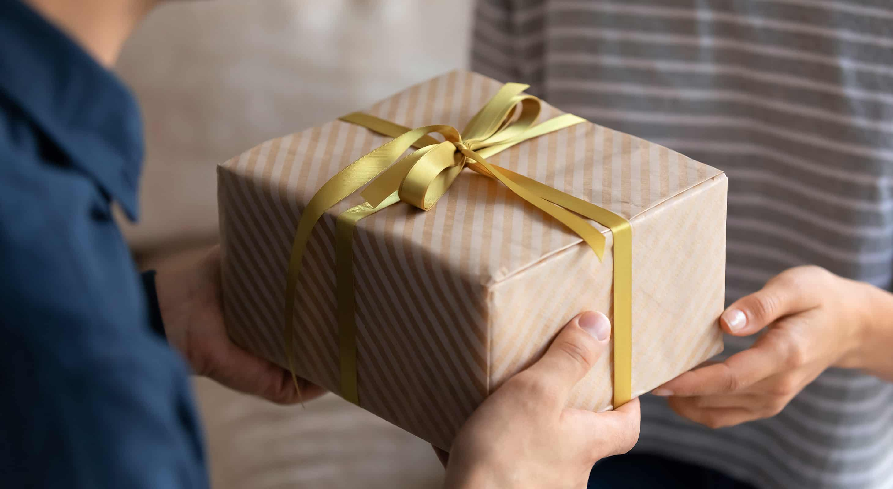 Man giving woman a gift with gold bow