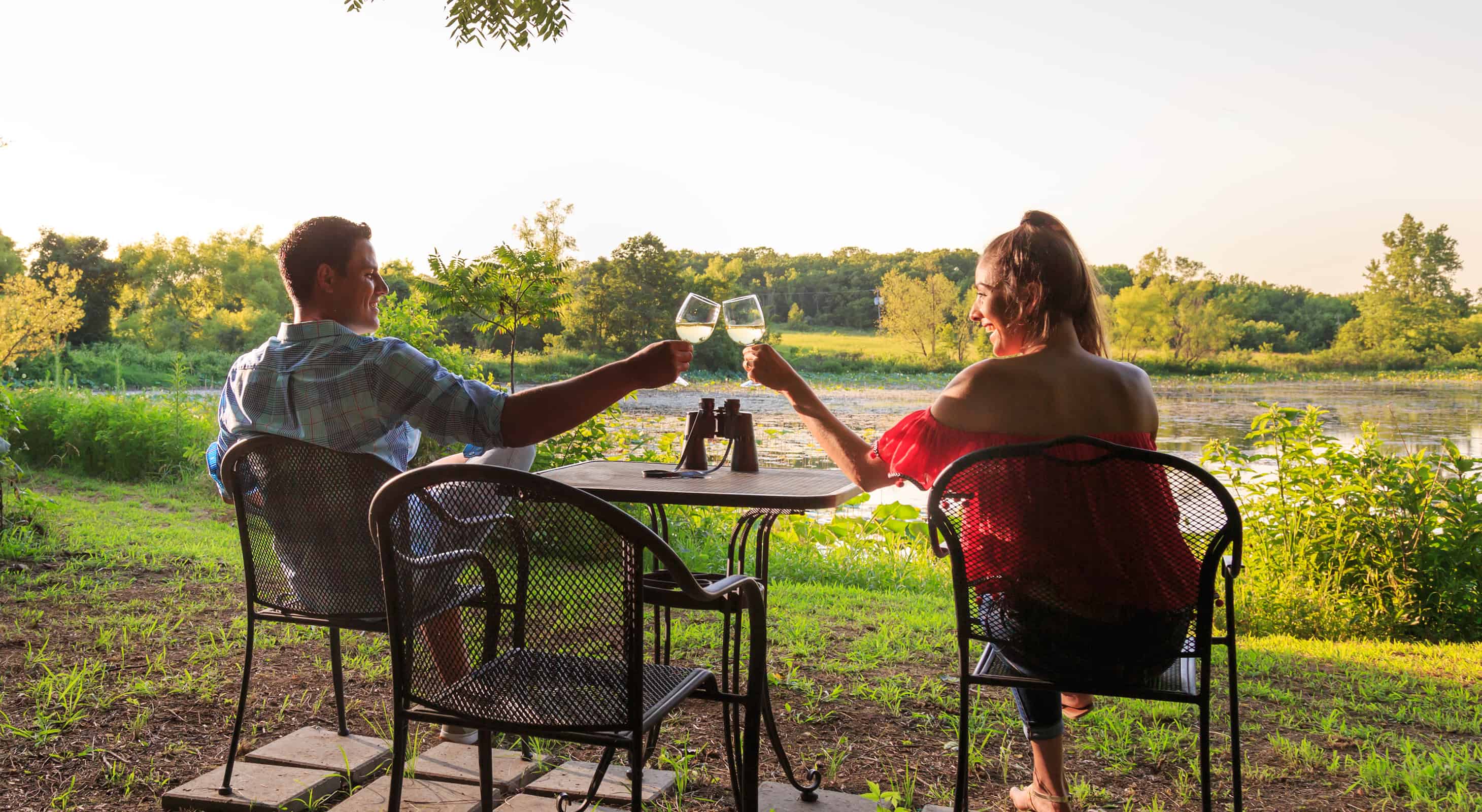 Couple toasting glasses of wine on the patio during a romantic getaway near Kansas City
