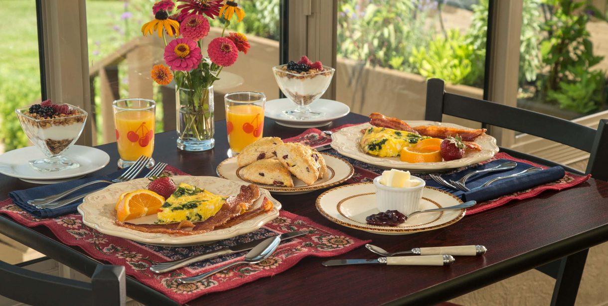 Table laid out for breakfast with numerous dishes