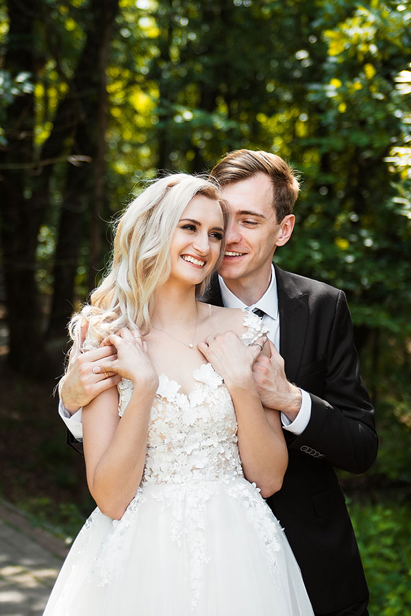 Bride and groom embracing in the woods