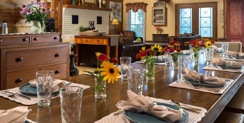 Dining table with small floral centerpieces within rustic lodge