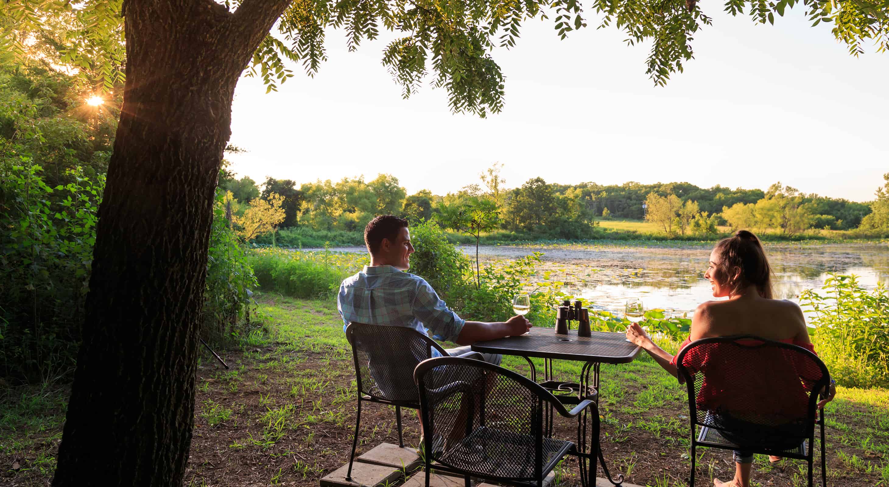 Couple enjoying wine by the pond