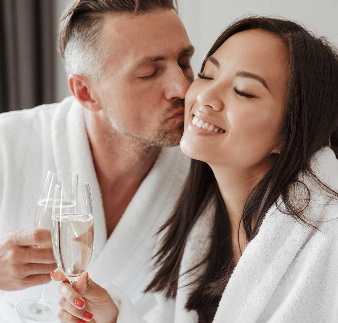 Couple with Champagne kissing during a spa getaway in Kansas