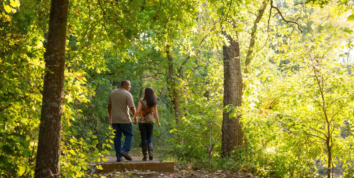 Couple walking in the woods at Kansas retreat