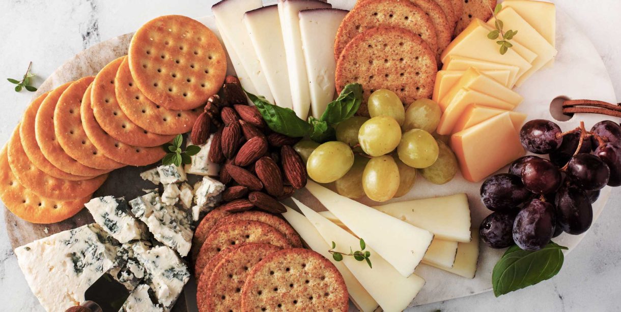 Meat and cheese plate with crackers and grapes