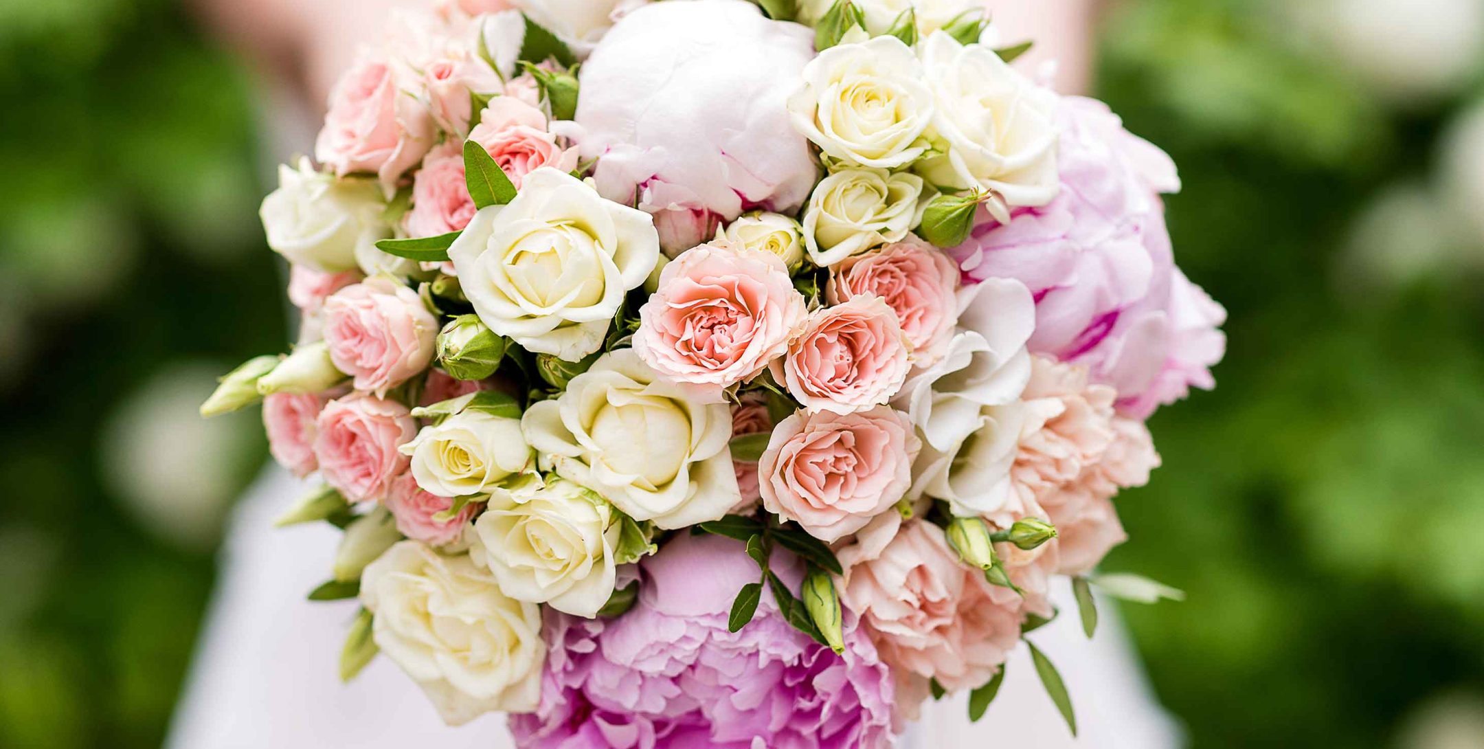 Close up of bride holding a pink and white wedding bouquet