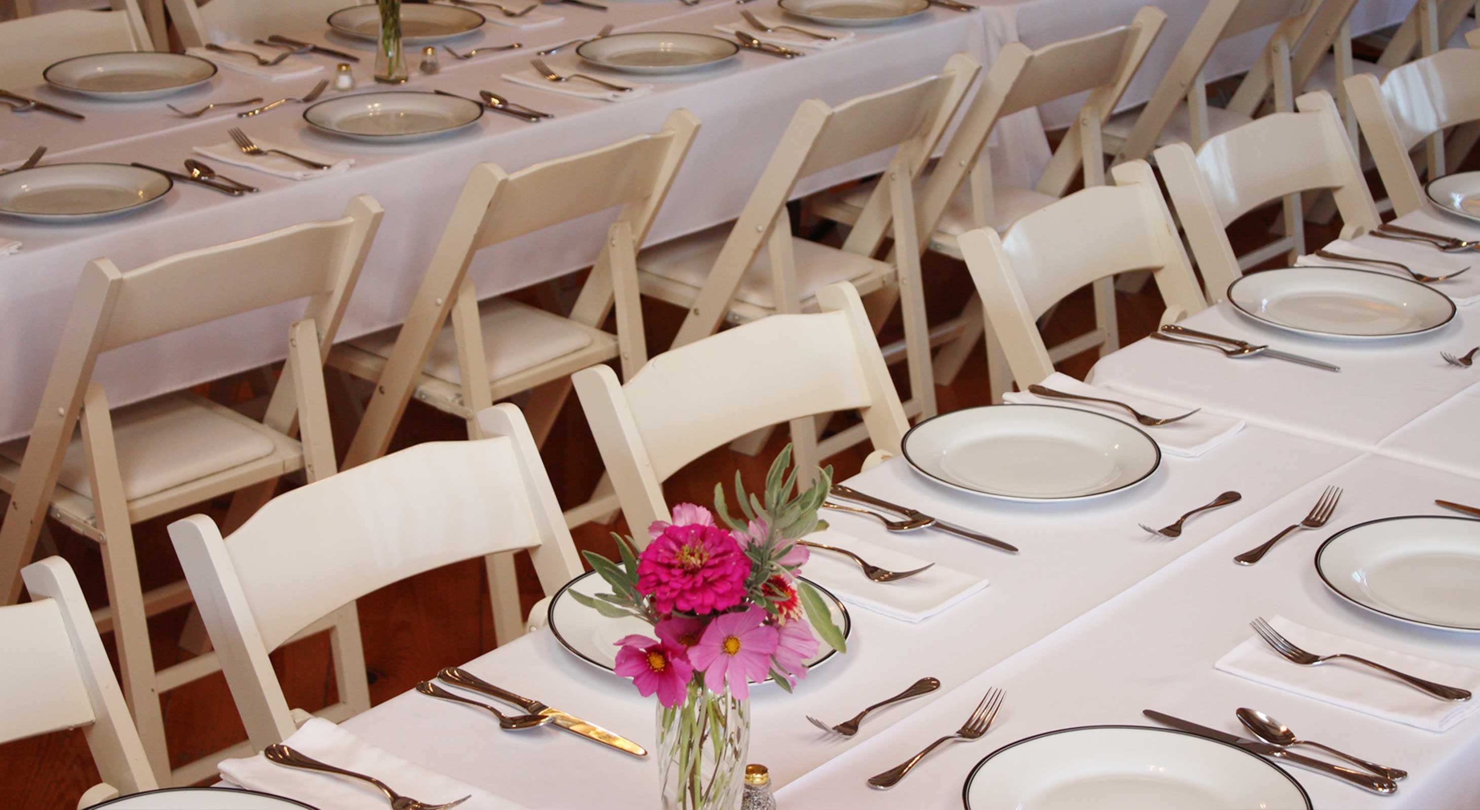 Wedding reception table place settings with pink flowers