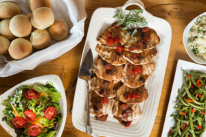 Grilled chicken, salad, and homemade rolls for a holiday gathering