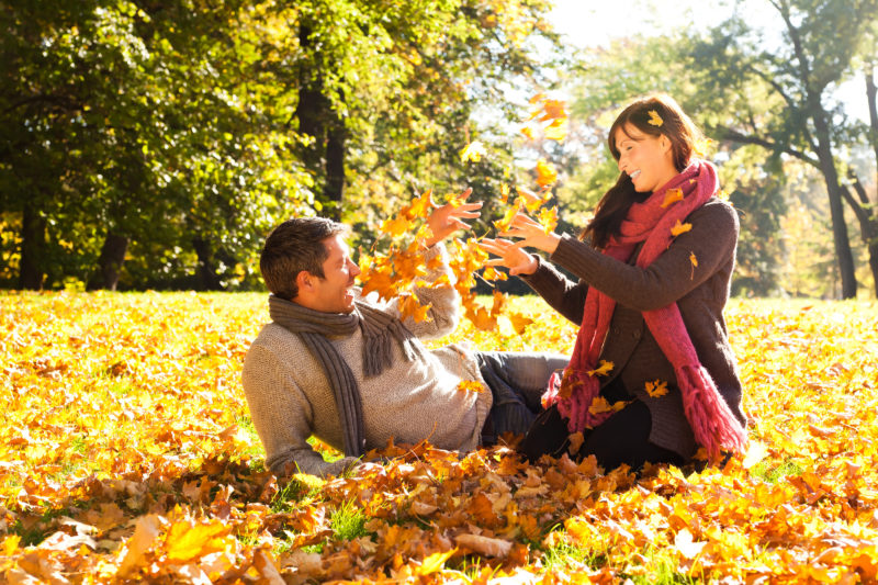 Happy couple playing in fall foliage at Cedar Crest Lodge in Pleasanton, Kansas