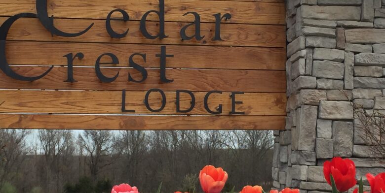Summer tulips in front of wooden Cedar Crest Lodge sign